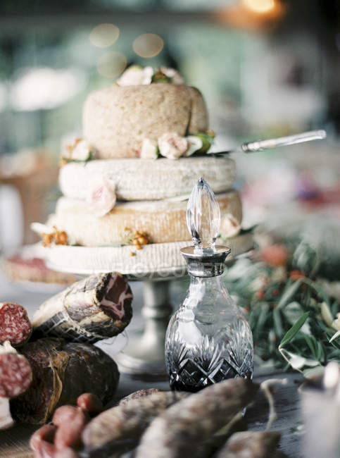 Carnes curadas, vinho e queijo italiano cabeças em cakestand — Fotografia de Stock