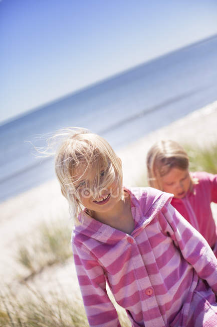 Due ragazze che camminano sulla spiaggia, si concentrano sul primo piano — Foto stock