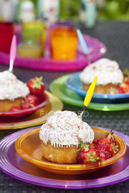Pratos de cupcakes com morangos frescos na mesa — Fotografia de Stock
