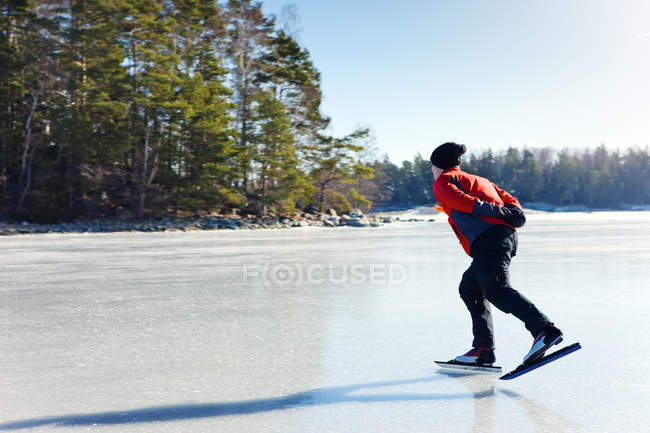 Homem patinagem no gelo em lago congelado, foco seletivo — Fotografia de Stock