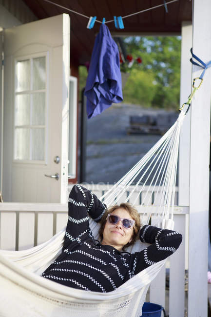 Mature woman relaxing in hammock, differential focus — Stock Photo
