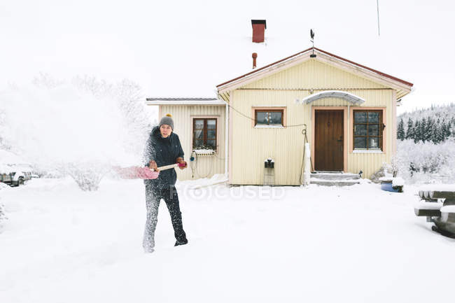 Homem pá de neve na frente da casa — Fotografia de Stock