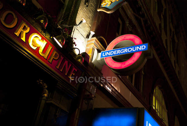 Signo subterráneo iluminado por la noche - foto de stock