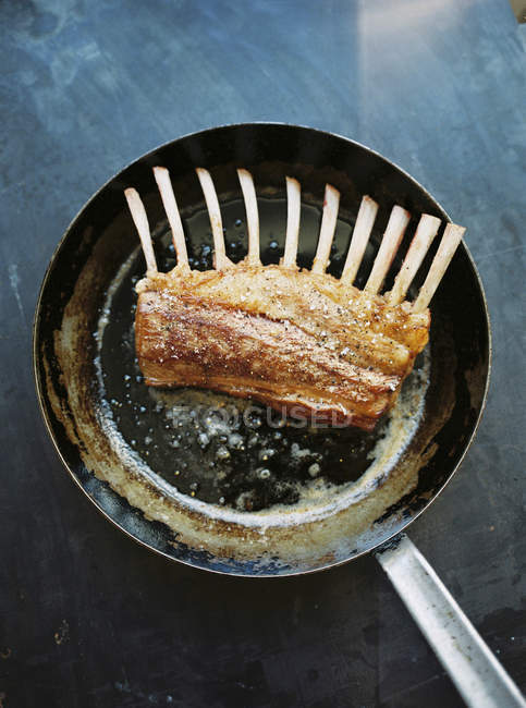 Cooked rack of lamb in frying pan — Stock Photo