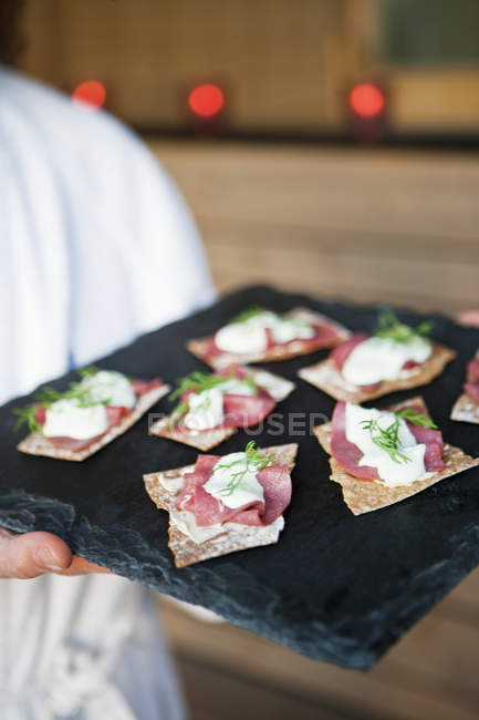 Male chief holding tray with appetizers — Stock Photo