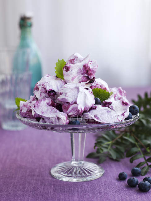 Bilberry meringues on cakestand with mint leaves — Stock Photo