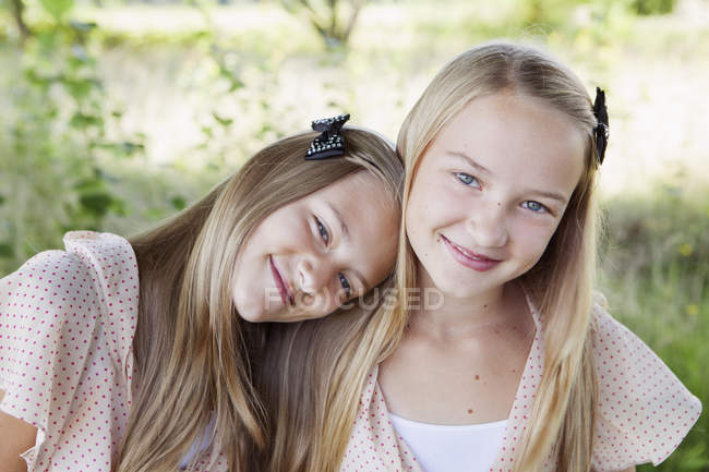 Портрет двух улыбающихся девушек, фокус на переднем плане — стоковое фото