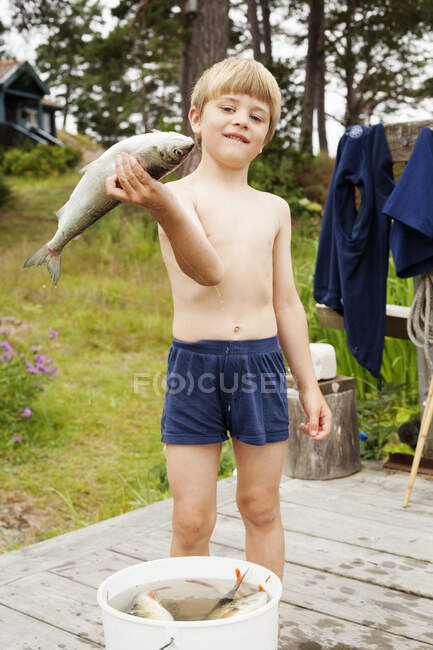 Retrato de menino segurando peixe — Fotografia de Stock
