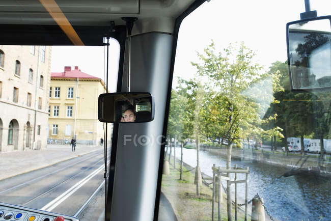 Reflexão do motorista de bonde feminino no espelho retrovisor — Fotografia de Stock