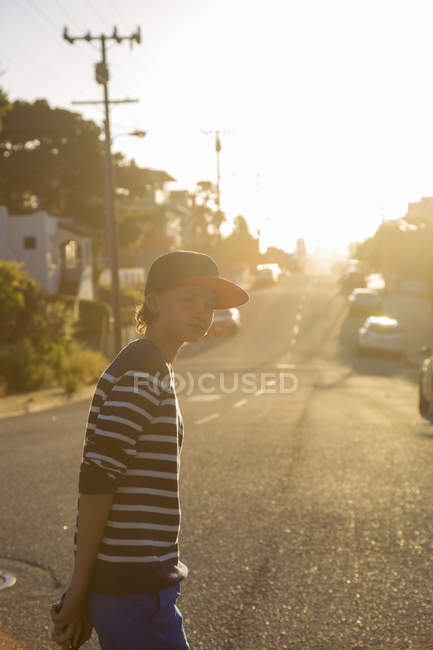 Junge steht auf Stadtstraße in pazifischem Hain — Stockfoto