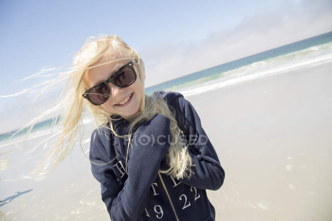 Улыбающаяся блондинка в солнечных очках на пляже — Горизонт над водой, Соленая вода - Stock Photo