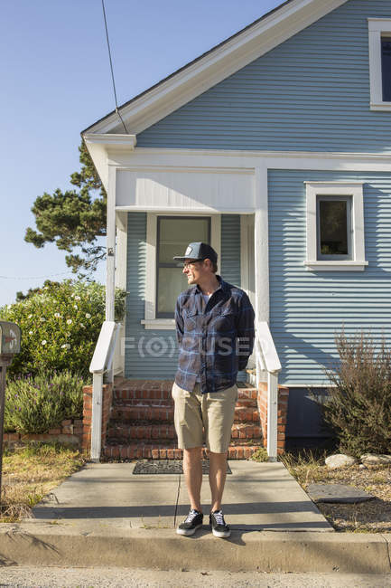 Uomo maturo in piedi di fronte alla casa blu a Pacific Grove — Foto stock