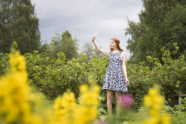 Frau macht Selfie in ländlicher Landschaft, selektiver Fokus — Stockfoto