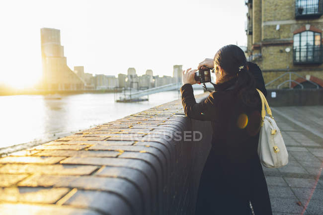 Mid adult woman taking pictures at riverbank in Rotherhithe — Stock Photo