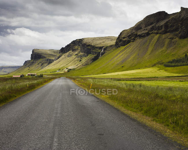 Vista ao longo da estrada que conduz através do vale da montanha — Fotografia de Stock