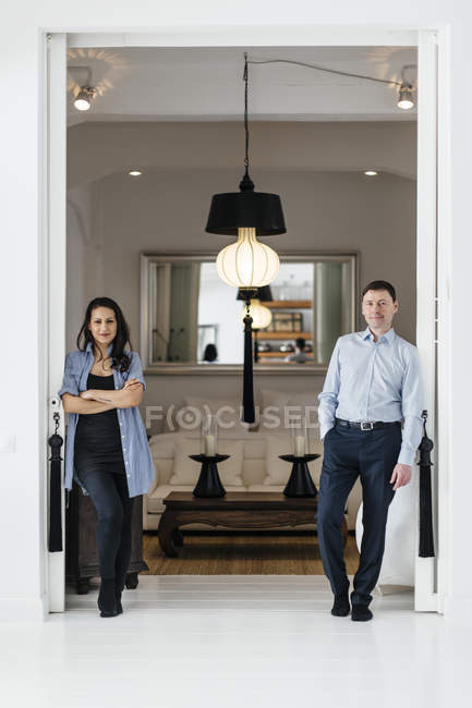 Mature couple standing in house, focus on background — Stock Photo