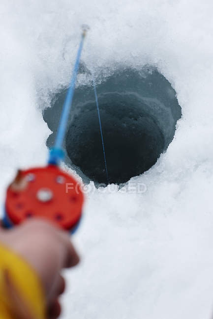 Vista ritagliata di uomo pesca sul ghiaccio — Foto stock