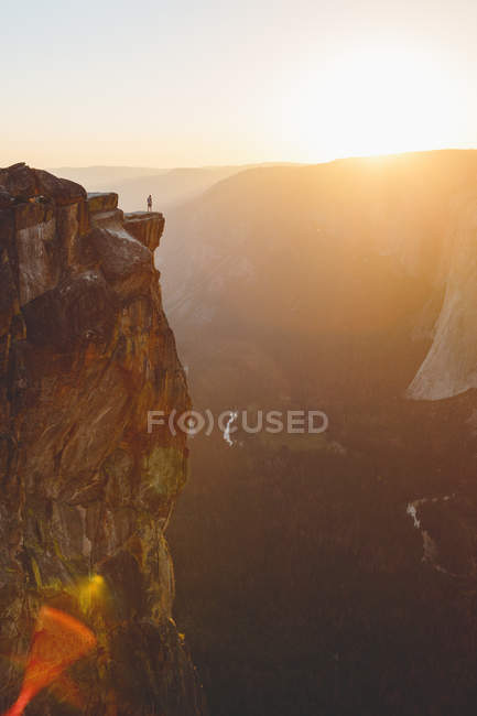 Scenic view of Yosemite National Park, man standing at edge of rock in background — Stock Photo