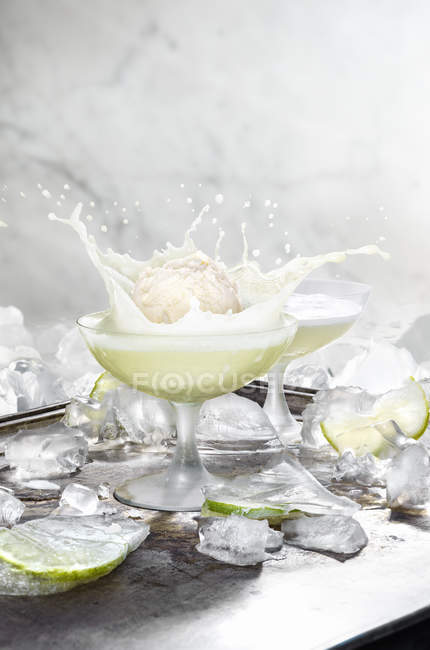 Still life with ice cream ball splashing in cocktail — Stock Photo
