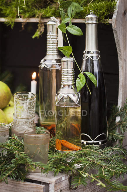 Vasos y botellas de vino en estante decorado - foto de stock