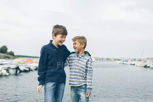 Ragazzi in piedi accanto al porto turistico e ridere, concentrarsi sul primo piano — Foto stock