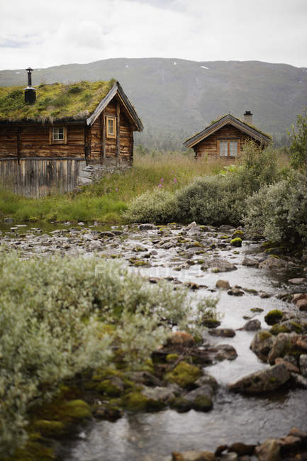 Старі дерев'яні будинки і скелястий струмок — стокове фото