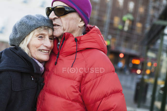 Casal sênior abraçando na parada de ônibus, foco seletivo — Fotografia de Stock