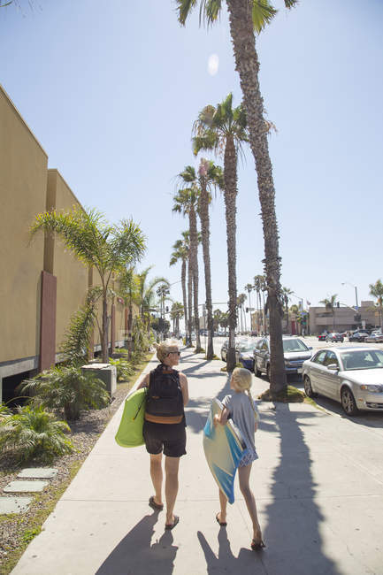 Жінка і дівчинка йдуть тротуаром у Сан - Дієго з пальмами. — стокове фото