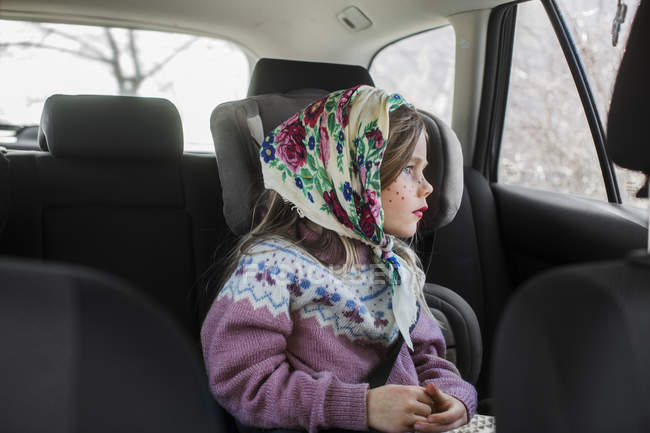 Девушка в костюме пасхальной ведьмы сидит в машине и смотрит в окно — стоковое фото