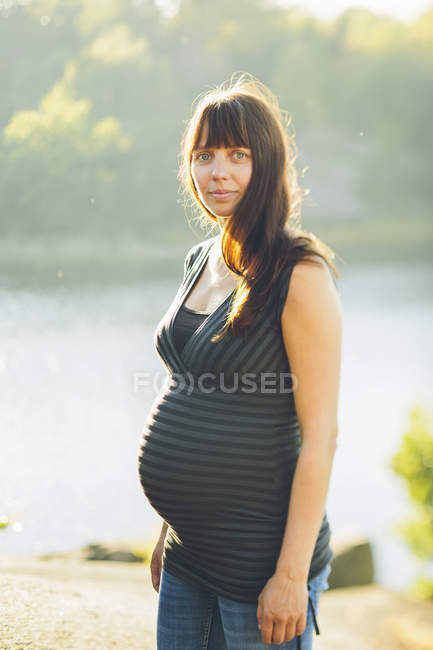 Портрет беременной женщины, смотрящей в камеру — стоковое фото