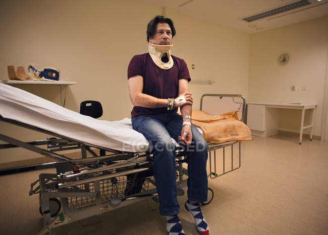 Uomo maturo seduto sul letto d'ospedale — Foto stock