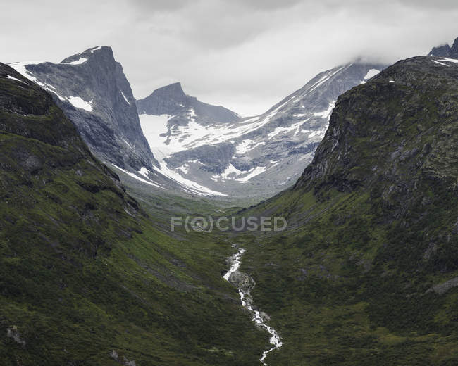 Gamma jotunheimen e lussureggiante valle verde sotto cielo nuvoloso — Foto stock