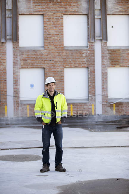 Retrato del hombre en ropa reflectante con el edificio en el fondo - foto de stock