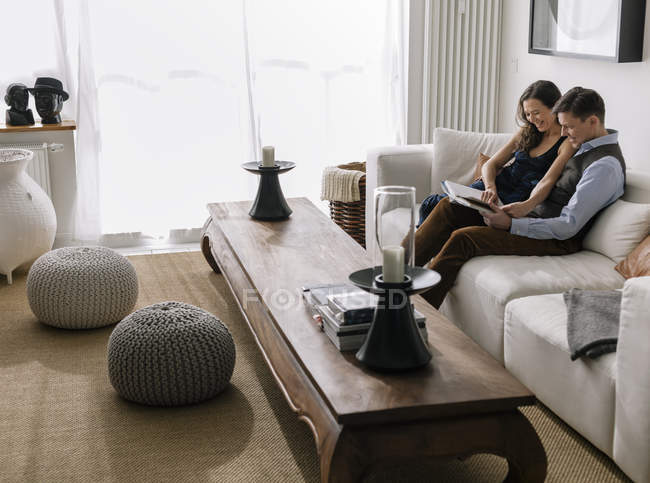 Coppia seduta sul divano in soggiorno, focus sullo sfondo — Foto stock