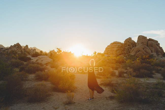 Donna vestita a piedi nel Parco Nazionale di Joshua Tree al tramonto — Foto stock