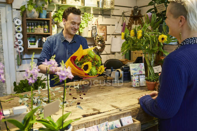 Fleuriste travaillant dans un magasin de fleurs — Photo de stock