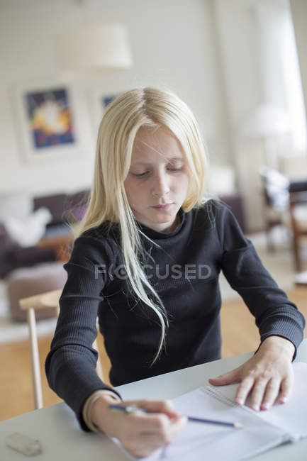 Girl writing in notebook, differential focus — Stock Photo