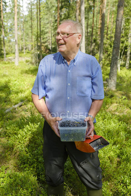 Hombre mayor sosteniendo cubo con arándanos - foto de stock