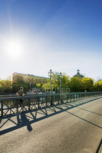 Young man running on bridge in Stockholm — Stock Photo