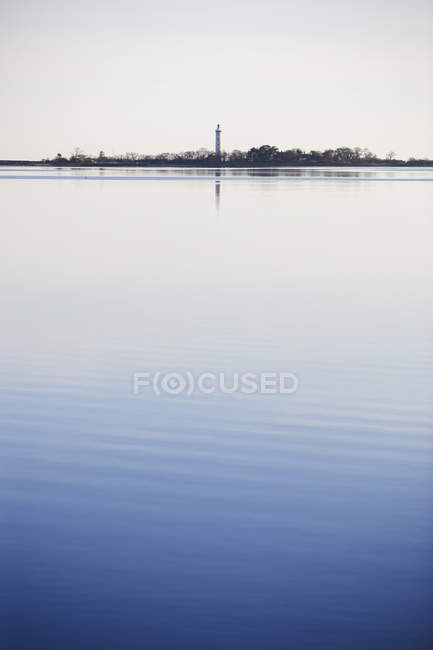 Морський пейзаж з маяком, що відображає у воді — стокове фото