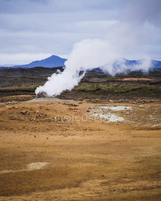 Vapor sobre aguas termales con cordillera en Islandia en el horizonte — Stock Photo
