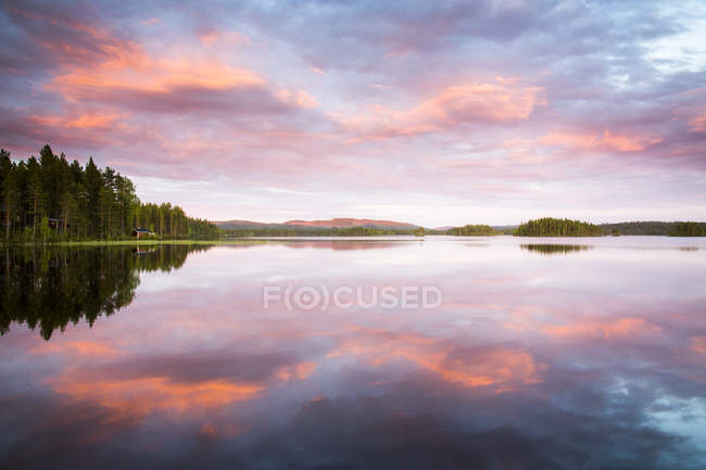 Vista panorâmica do céu por do sol refletindo na água do lago — Fotografia de Stock