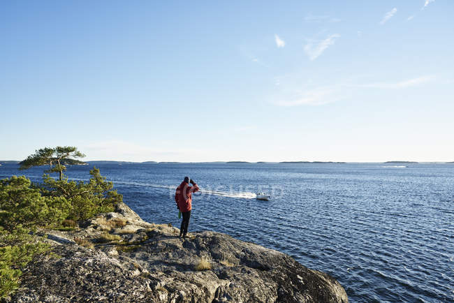 Hombre mirando a la vista mientras barco a motor en el mar, enfoque diferencial - foto de stock