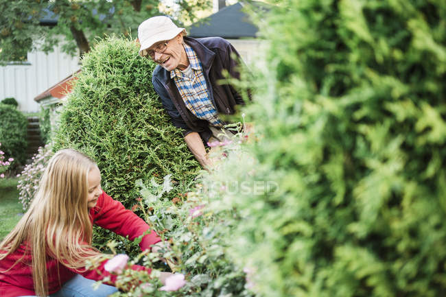 Grandfather and granddaughter working in garden — Stock Photo