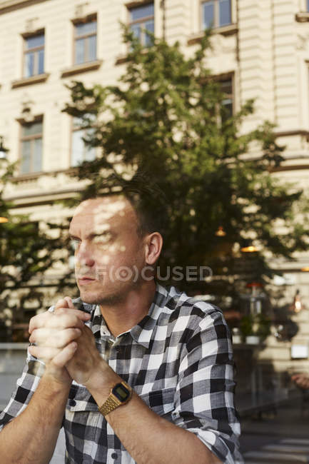 Front view of man sitting with hands clasped — Stock Photo