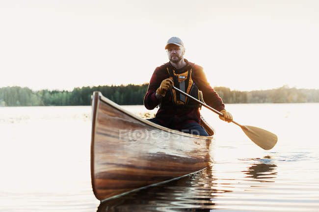 Homem remando canoa no lago — Fotografia de Stock