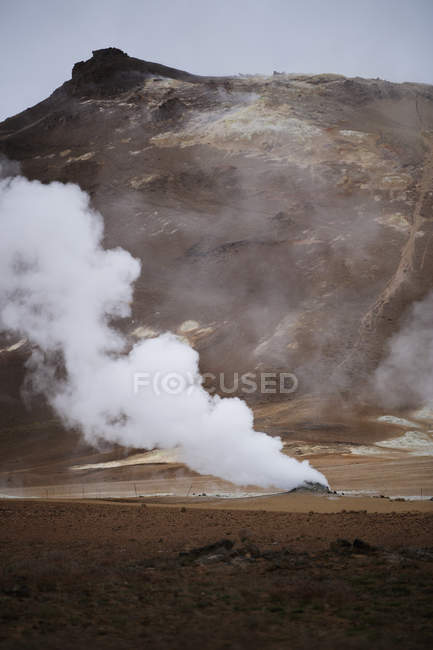 Vapor sobre aguas termales con cordillera en Islandia - foto de stock