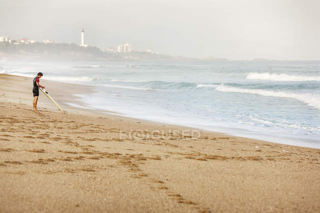 Surfeur debout sur la plage à Biarritz, France — Photo de stock