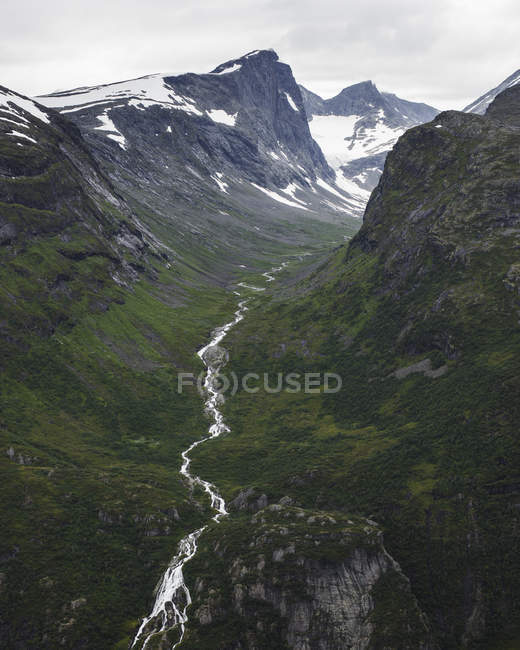 Jotunheimen range and lush green valley under cloudy sky — Stock Photo