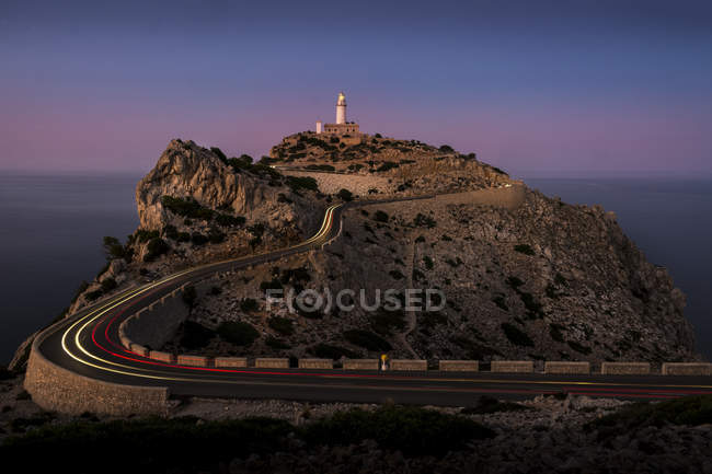 Faro sul ciglio della scogliera al tramonto, Cap Formentor, Spagna — Foto stock